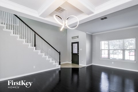 A spacious room with a staircase and a door.