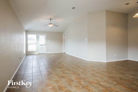 A spacious room with a ceiling fan and tile flooring.