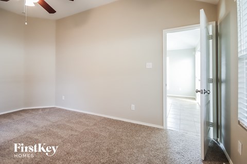 A room with a carpeted floor and a door leading to another room.
