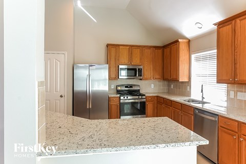 A kitchen with wooden cabinets and granite countertops.