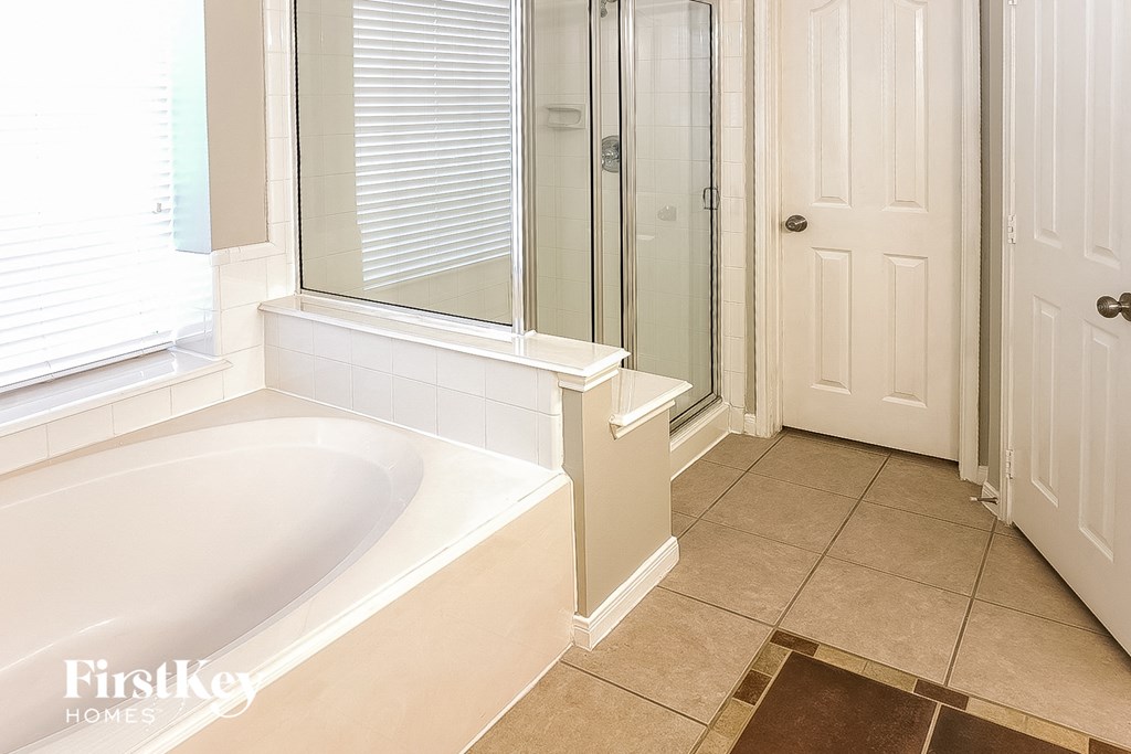 A bathroom with a tub and a door.