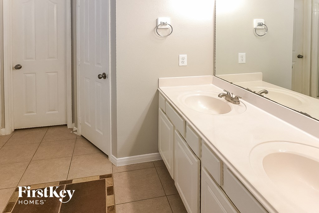A bathroom with a sink and mirror.