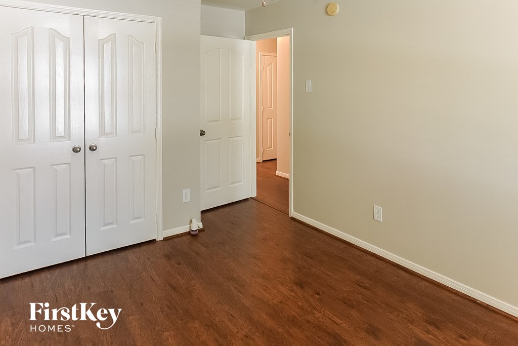 A room with wooden floors and two white doors.