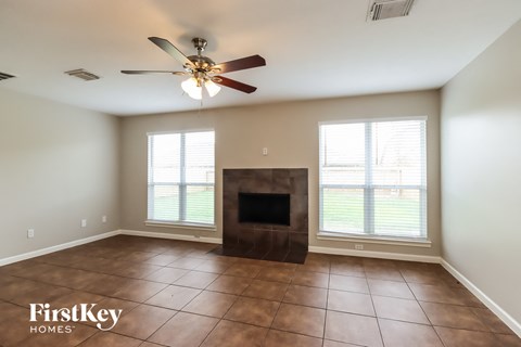 a living room with a fireplace and a ceiling fan