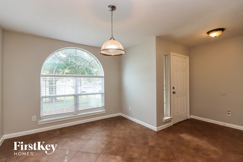 an empty dining room with a large window and a door