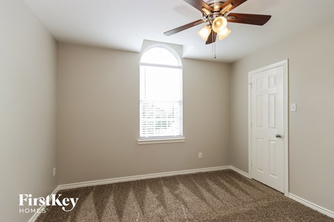 a bedroom with a ceiling fan and a window