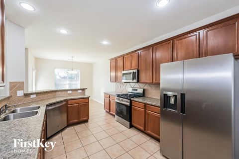 A kitchen with brown cabinets and a stainless steel refrigerator.