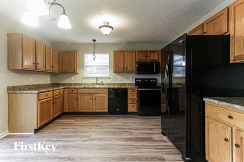 a kitchen with wooden cabinets and black appliances