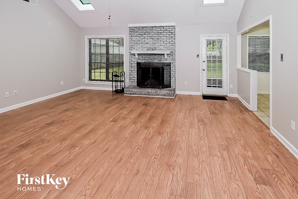 the living room has a fireplace and a wooden floor