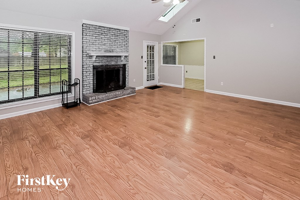 the living room has a fireplace and wood flooring