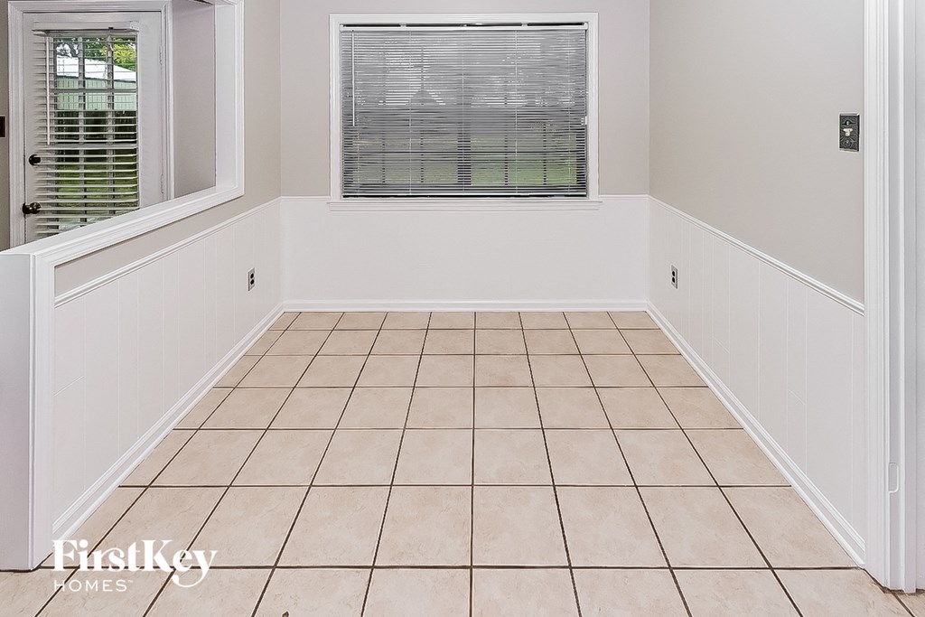a small room with a window and a tiled floor