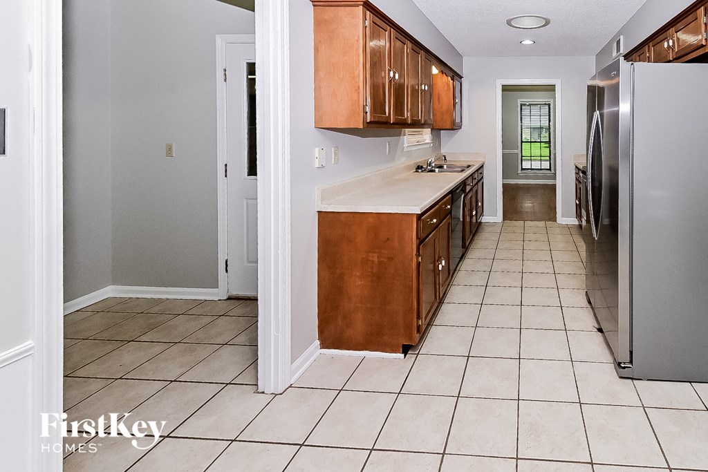 a kitchen with wooden cabinets and a tiled floor