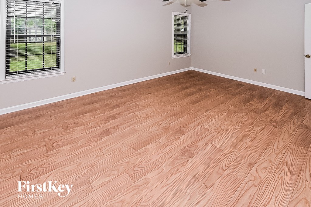 an empty room with wood flooring in a home