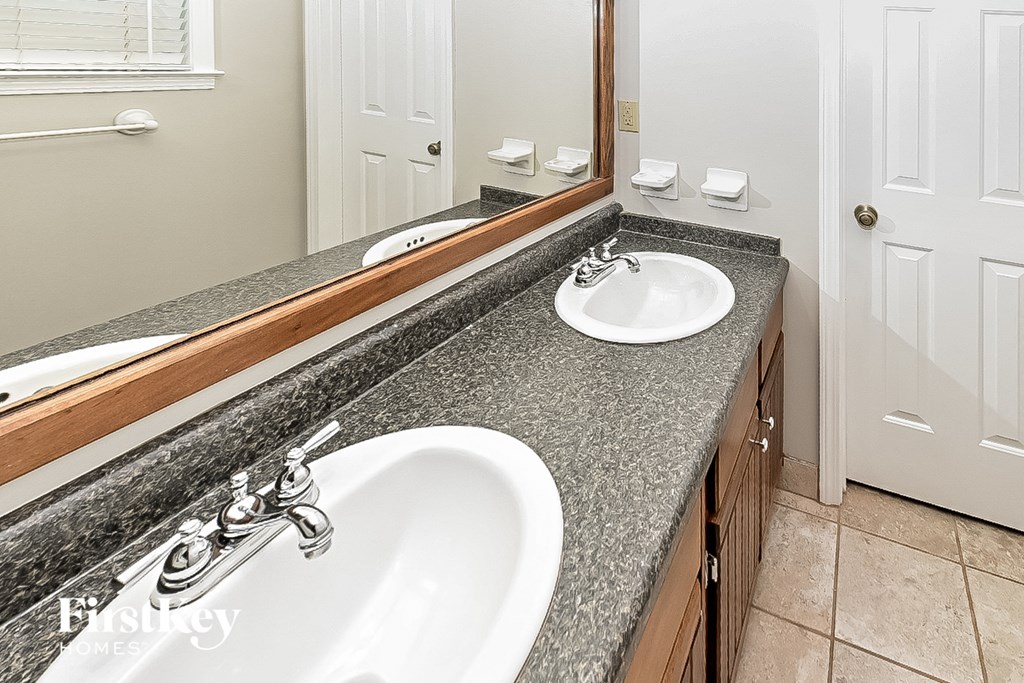 a bathroom with two sinks and a large mirror