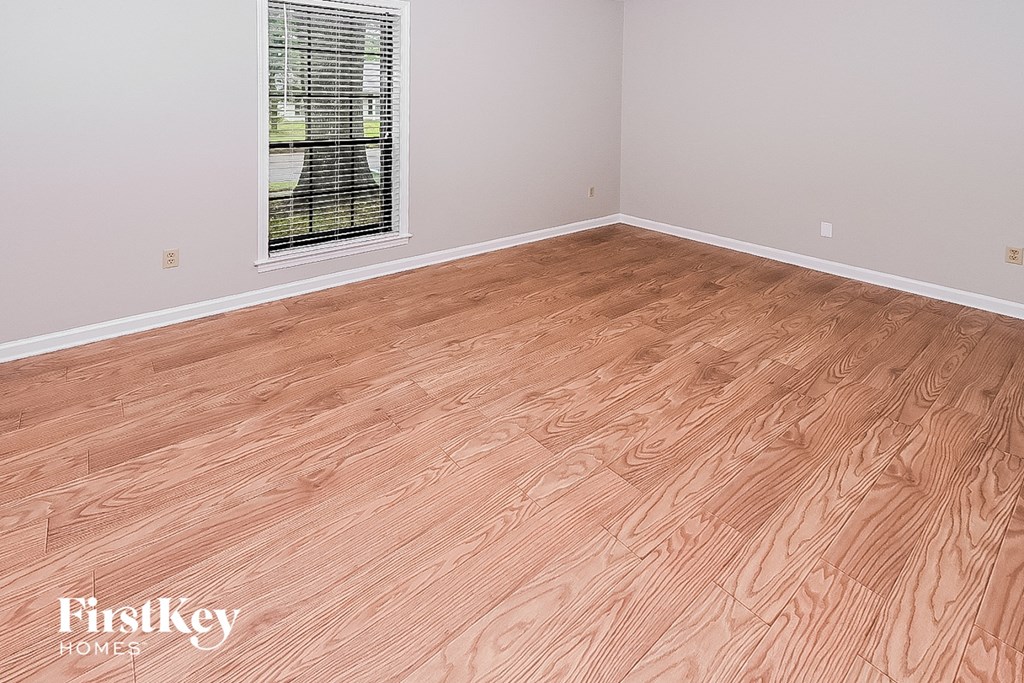 the living room of an empty house with a wooden floor