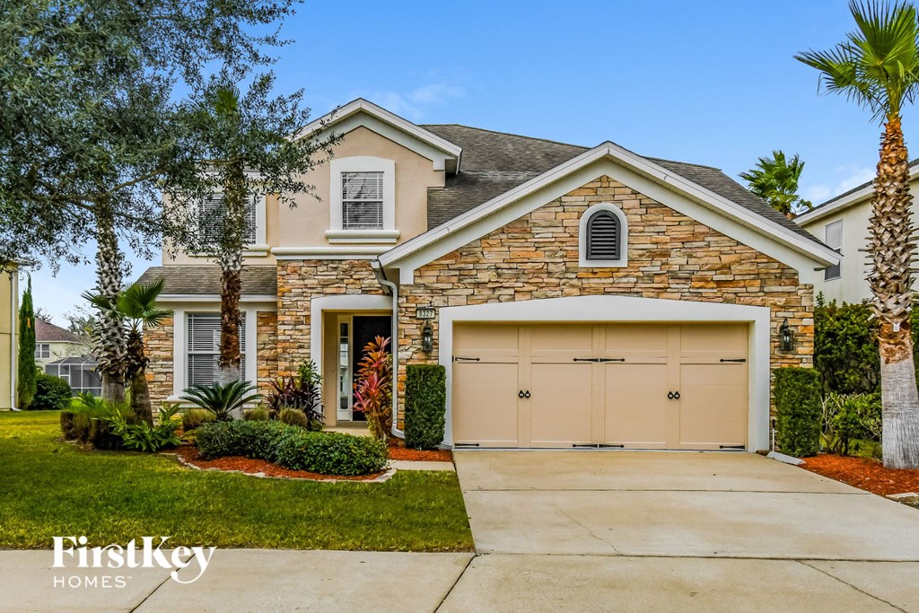 A house with a stone facade and a garage door.