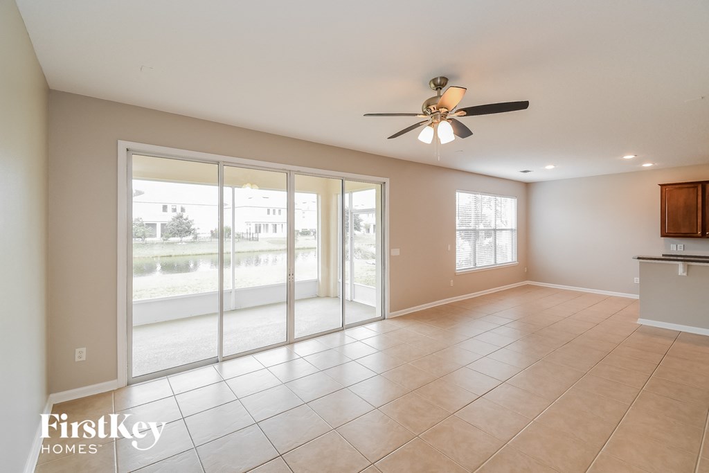 A spacious room with a ceiling fan and sliding glass doors.