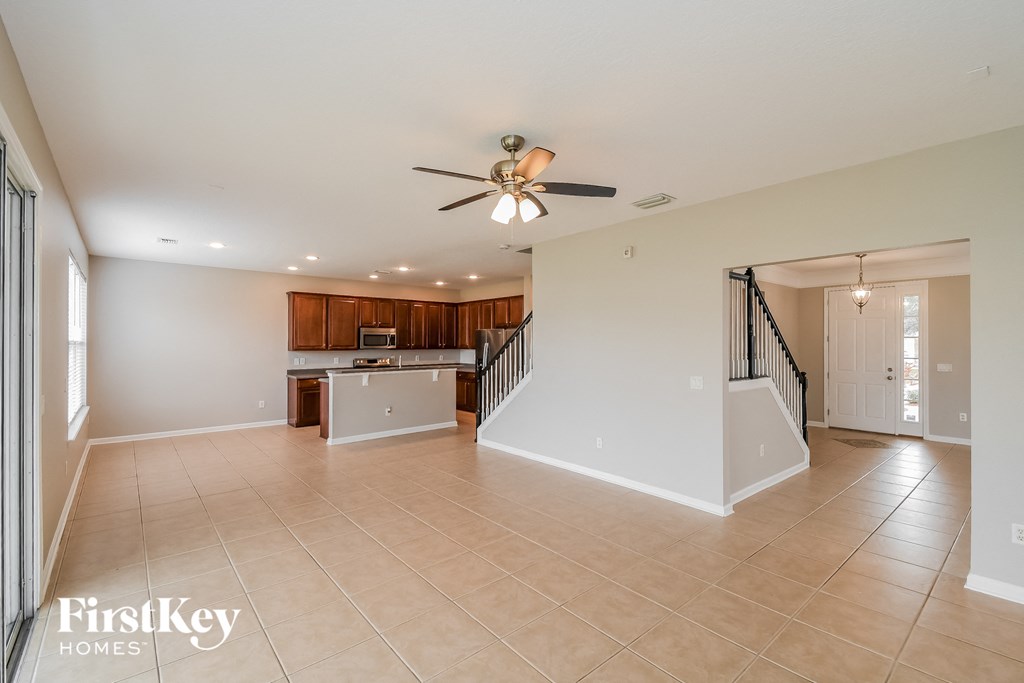 A spacious living room with a staircase leading to the upper floor.