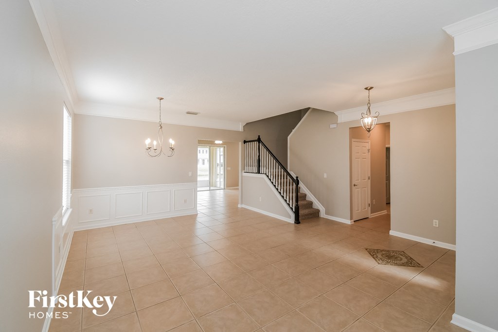 A spacious living room with a staircase leading to the upper floor.