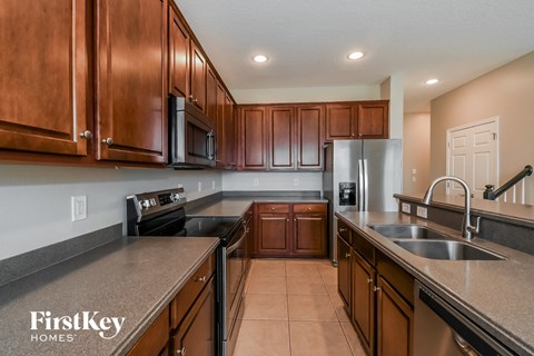 A kitchen with brown cabinets and a stainless steel refrigerator.