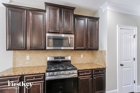 A kitchen with brown cabinets and a stove top oven.
