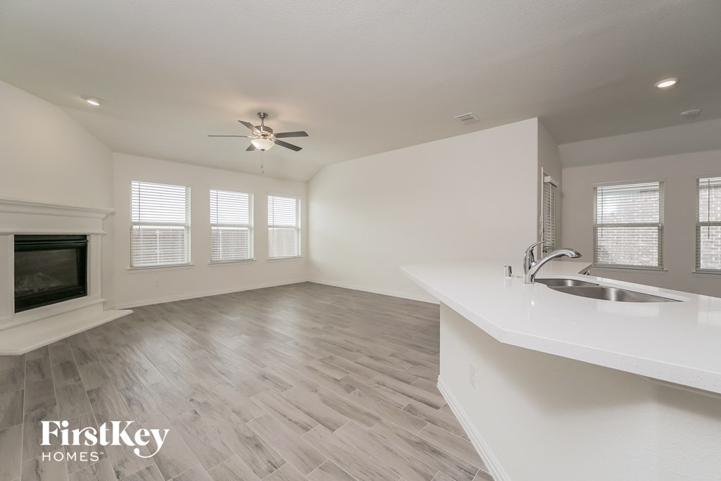 a kitchen and living room with a sink and a fireplace