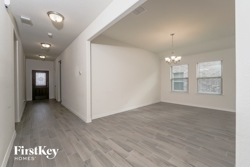 the living room and dining room with the hallway to the front door