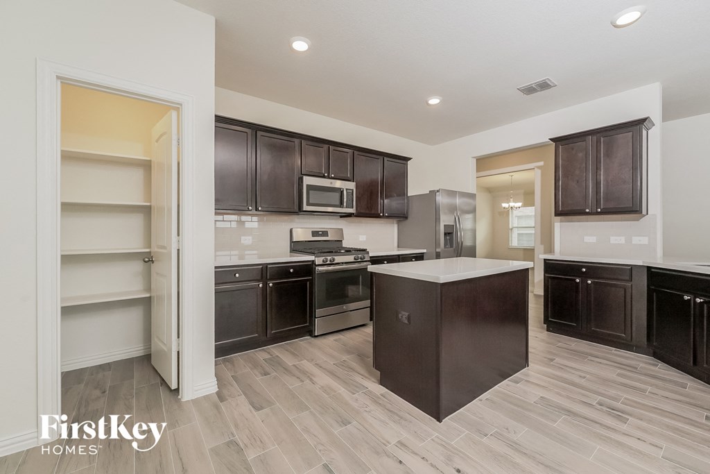 a kitchen with dark wood cabinets and a white counter top