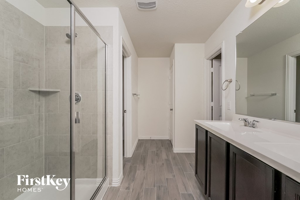 a bathroom with a shower and a sink and a mirror
