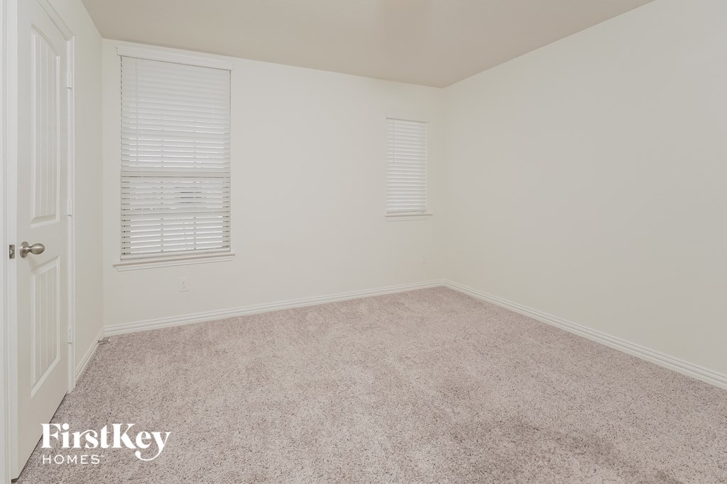 a bedroom with a carpeted floor and two windows