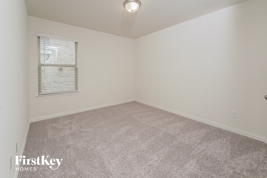 a spacious living room with carpet and a window