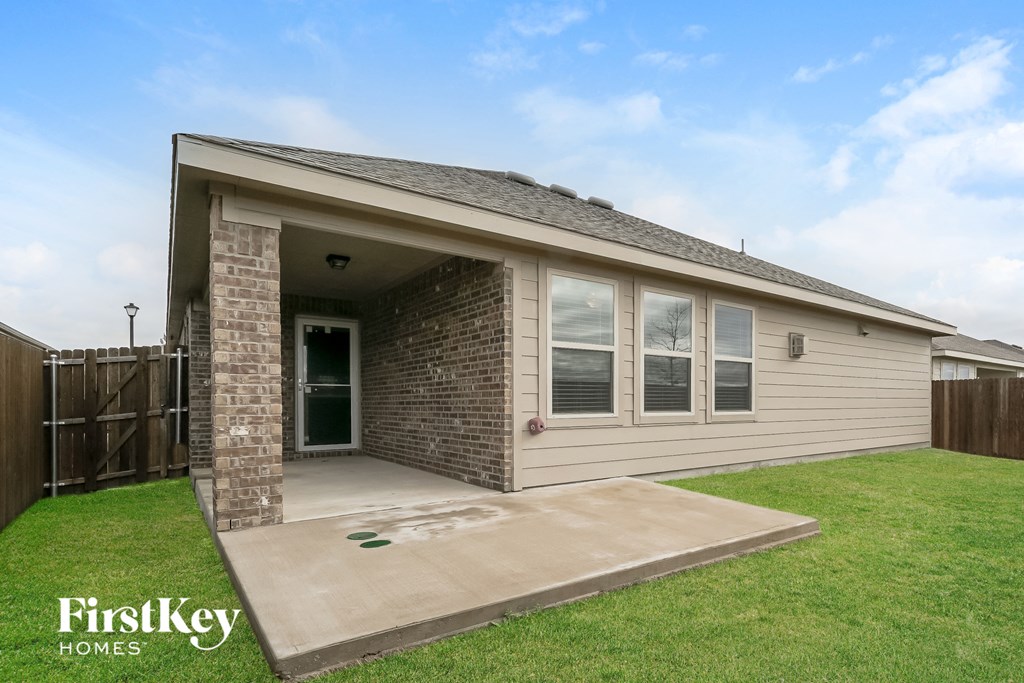 the backyard of a house with a lawn and a porch