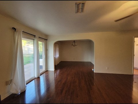 an empty living room with hard wood floors and white walls
