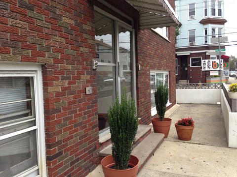 the outside of a brick building with potted plants