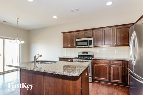 A kitchen with wooden cabinets and a granite countertop.