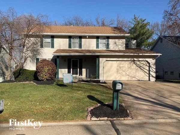 A house with a green lawn sign in front of it.