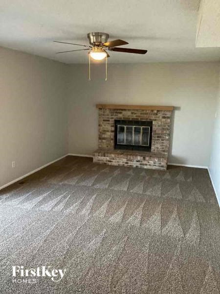 A room with a fireplace and a fan on the ceiling.