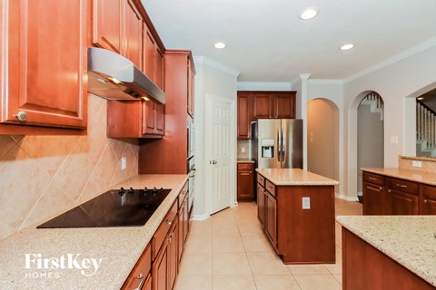 a kitchen with wooden cabinets and granite counter tops and a stainless steel refrigerator