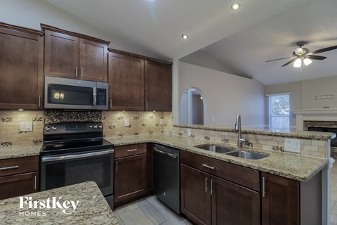 a kitchen with granite counter tops and wooden cabinets