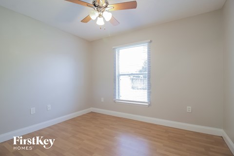 a living room with wood floors and a ceiling fan