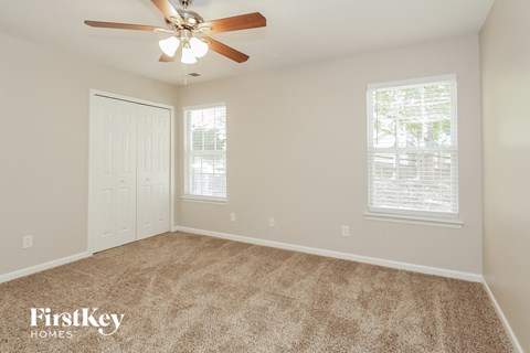 a bedroom with carpet and a ceiling fan