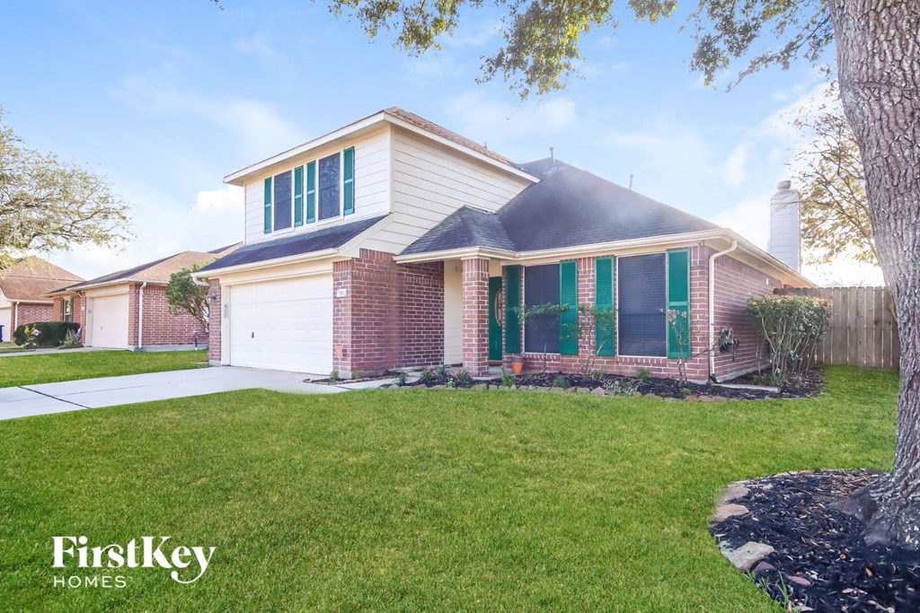 A house with a white garage door and green shutters.