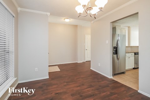 A well lit kitchen area with a refrigerator and a dining table.