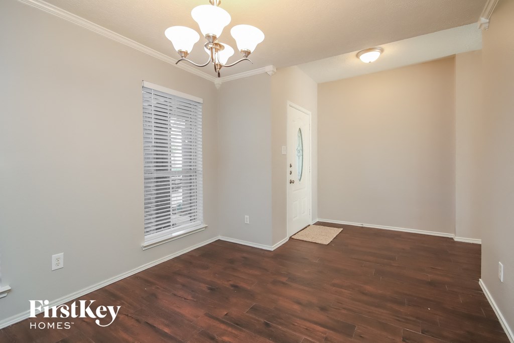 A room with wooden floors and a chandelier.