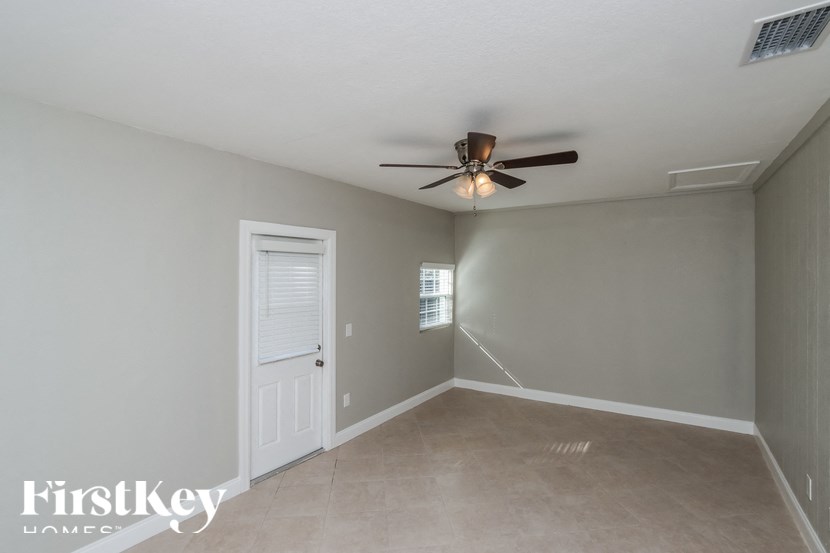 an empty room with a ceiling fan and a door