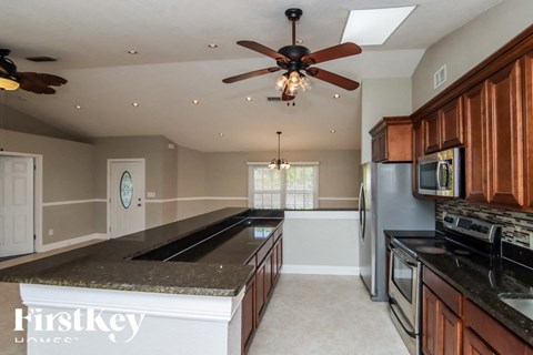 a kitchen with a large island and a ceiling fan