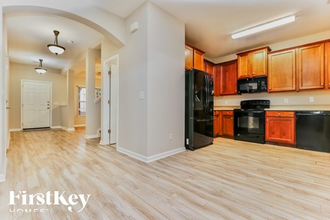 A kitchen with wooden cabinets and black appliances.