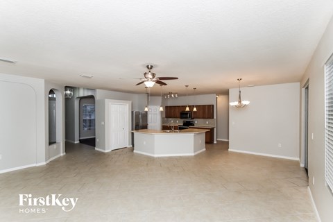 an open kitchen and living room with a ceiling fan