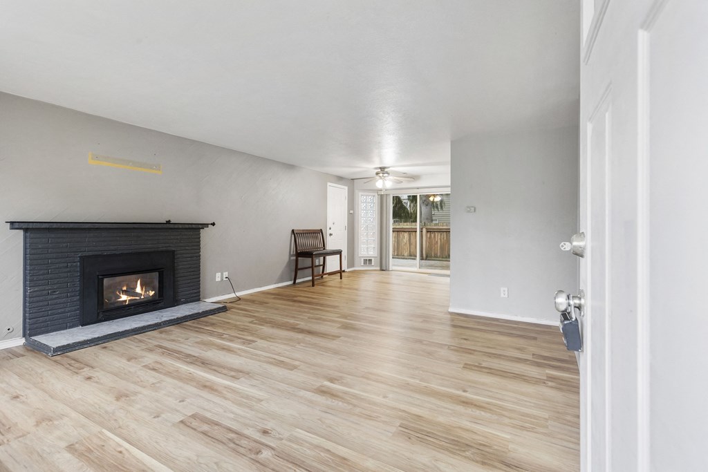 a living room with a fireplace and a wooden floor