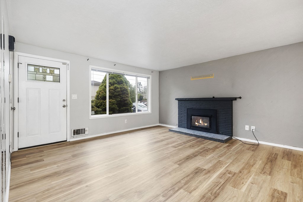 an empty living room with a fireplace and a window
